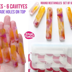 以下が含まれることがあります： レジンジュエリーを作るための透明なシリコンモールド6個セット。モールドは丸みを帯びた角を持つ長方形の形で、上部に予め穴が開いています。モールドは、黄色、オレンジ、ピンクのレジンパーツと一緒に表示されています。