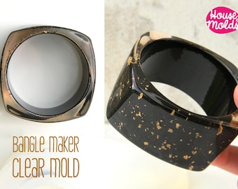 May include: A black square bangle mould with gold flecks. The mould is made of clear plastic and is designed to create a bangle with a square shape. The mould is shown with a finished bangle made with it, which is also black with gold flecks. The text "House of Molds" is visible in the image.