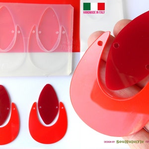 May include: Two pairs of red and pink resin earrings. The earrings are shaped like a teardrop with a crescent moon shape on the bottom. The earrings are handmade in Italy.