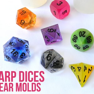 Può includere: Un set di sette dadi in resina trasparente e colorata con numeri neri. I dadi sono di varie forme, tra cui un d4, d6, d8, d10, d12 e d20. I dadi sono su una superficie bianca. Il testo "SHARP DICES CLEAR MOLDS" è in lettere rosa nella parte inferiore dell'immagine. Il testo "House Molds" è in un cerchio nella parte inferiore destra dell'immagine.