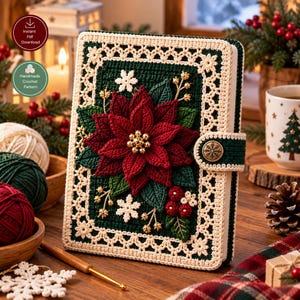 May include: A rectangular notebook cover featuring a dark green crocheted base with a cream-colored lace border. The front displays a large, three-dimensional red poinsettia flower with gold beads at the center, green leaves, and white snowflakes.