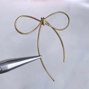 テクスチャード加工の真鍮製ボウチャーム：ゴールドトーンのワイヤーリボン金具（4個）