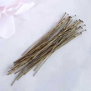 May include: A pile of gold-colored head pins, used for jewelry making and crafting.