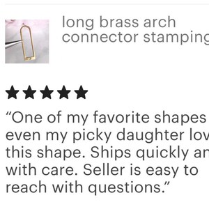 May include: A close-up of a gold-colored metal arch connector stamping. The connector is long and narrow, with a rounded top and bottom. The image includes a five-star rating and a customer review that reads: "One of my favorite shapes - even my picky daughter loves this shape. Ships quickly and with care. Seller is easy to reach with questions."