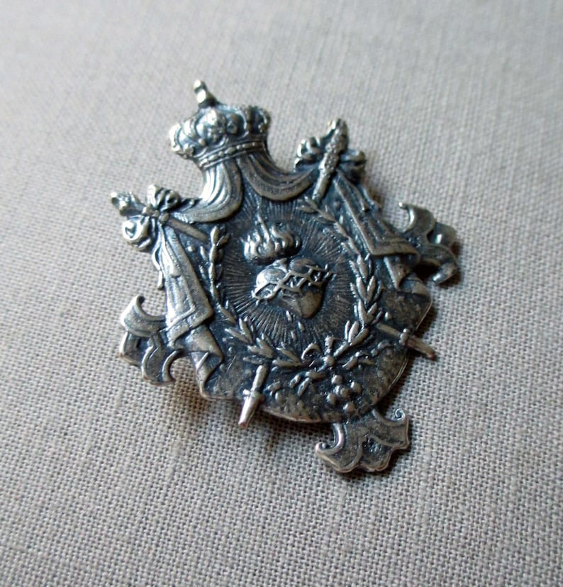 silver plated shield charm or pendant medal with crown sacred heart and swords jewelry finding
