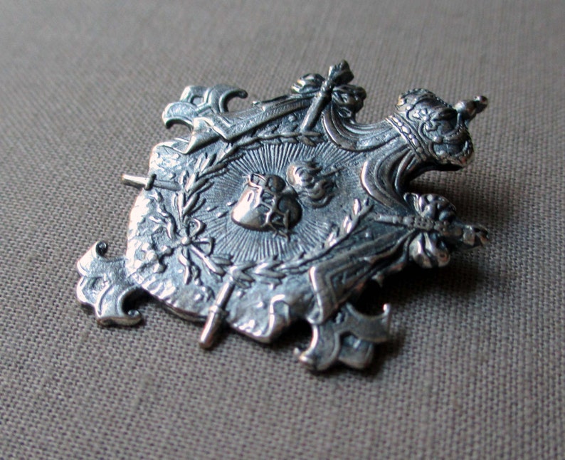 silver plated shield charm or pendant medal with crown sacred heart and swords jewelry finding