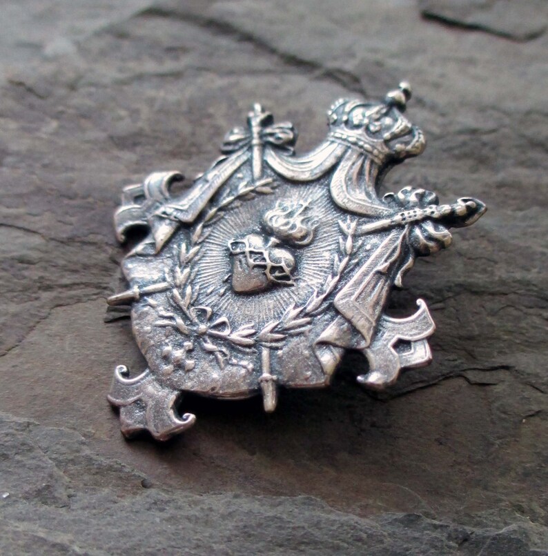 silver plated shield charm or pendant medal with crown sacred heart and swords jewelry finding