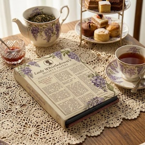 Może przedstawiać: Beżowa okładka książki z napisem "Lady Whistledown's Society Papers" i kwiatowymi ilustracjami, umieszczona na koronkowej serwetce. Na stole znajdują się również czajniczek, filiżanka i ciastka.