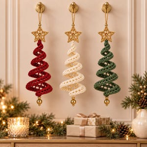 May include: Three hanging spiral Christmas tree ornaments in red, cream, and green. Each tree is crocheted with a textured pattern, topped with a gold crocheted star, and finished with a small gold bead at the bottom, suspended by a gold cord.