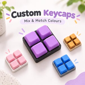 Könnte beinhalten: Vier Sets quadratischer mechanischer Tastaturkappen in Lila, Pink, Gold und Blau, jeweils in einem Zwei-mal-zwei-Raster auf einer Basis angeordnet. Der Text Custom Keycaps Mix & Match Colours steht in dunkelgrauer und lila Schrift über den Tastenkappen.
