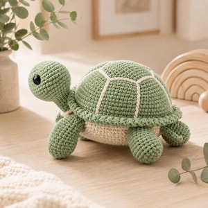 Peut inclure: Une tortue en crochet avec une carapace vert sauge ornée de détails cousus blancs, une tête verte assortie avec des yeux en plastique noir et un dessous de couleur crème. Ce jouet en peluche possède quatre pattes courtes et arrondies.