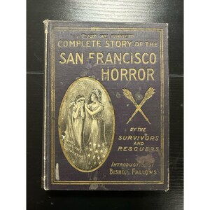 Peut inclure: Un livre relié violet foncé intitulé "Complete Story of the San Francisco Horror" avec des lettres dorées. La couverture présente une illustration ovale de deux personnages et des torches croisées, avec le texte "Lest We Forget" et "By the Survivors and Rescuers" imprimé en or.