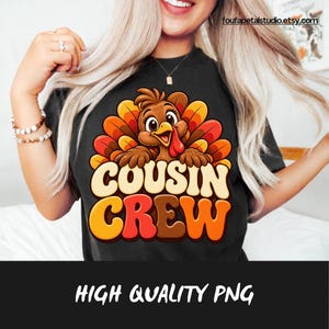 Puede incluir: Una camiseta negra con un dibujo de un pavo con plumas marrones, naranjas y amarillas. Debajo del pavo, el texto "COUSIN CREW" aparece en letras grandes, negritas y multicolores. El diseño está centrado en la parte delantera.
