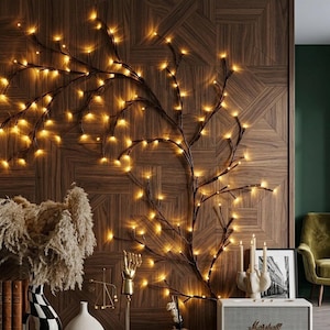 May include: A wall-mounted decorative branch structure featuring numerous small, warm-toned LED lights. The dark, slender branches extend across the wall in an organic, sprawling pattern, with the glowing lights attached to the tips of the twigs.
