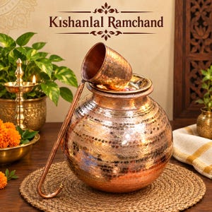 May include: A hammered copper pot with a matching long-handled ladle resting on top. The pot features a rounded body with horizontal bands of textured indentations. The text "Kishanlal Ramchand" is displayed in dark brown lettering above the pot.