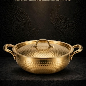 May include: A gold-coloured hammered brass kadhai with a matching lid and two side handles. The text reads: KISHAN LAL RAMCHANDRA BRASS MERCHANT, Pure Brass, Hammered Kadhai with Lid, 1.716 kg, TRADITIONAL CRAFT, TIMELESS QUALITY, HERITAGE SINCE 1947.