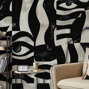 Peut inclure: Une peinture murale présentant un motif graphique abstrait en noir et blanc à grande échelle composé d'yeux humains et de lignes fluides. Le design recouvre tout le mur derrière une étagère en métal, une petite table d'appoint et un canapé beige.
