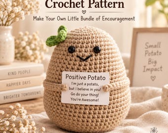 Pode incluir: Uma figura de batata em crochê bege com olhos de contas pretas e um sorriso bordado, apresentando uma pequena folha verde no topo. Segura uma placa branca que diz: Positive Potato, I'm just a potato, but I believe in you!