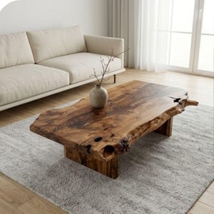 May include: A low coffee table crafted from a single slab of natural wood with a live edge, featuring a rich brown grain, knots, and organic textures. The table is supported by two thick wooden block legs and holds a small ceramic vase.