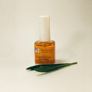 May include: A small amber glass bottle with a white cap, labelled "Scentimental Creations Cuticle Care Nail Therapy Carrot Tissue, Rosehip and Jojoba Oils of Lavender, Lemon and Rose"