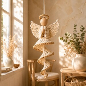 Peut inclure: Une d&eacute;coration d'ange en crochet suspendue avec une t&ecirc;te en perle de bois lisse, une aur&eacute;ole et des ailes en fil couleur cr&egrave;me. Le corps se compose d'une robe &eacute;vas&eacute;e qui se prolonge en une longue queue en spirale, orn&eacute;e de fins liser&eacute;s dor&eacute;s.