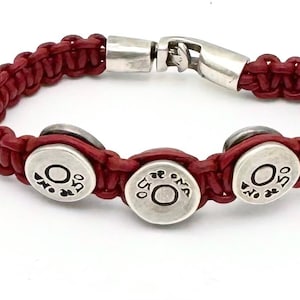 May include: Red leather bracelet with three silver round charms that say "O.S.O."
