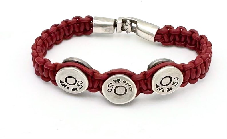 May include: Red leather bracelet with three silver round charms that say "O.S.O."