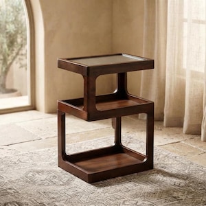 May include: A dark brown wooden side table featuring three stacked, open-frame tiers with a smooth finish. The structure consists of a rectangular top surface, a middle shelf, and a base shelf, all connected by vertical supports in a continuous design.