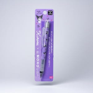 Könnte beinhalten: Ein violetter Druckbleistift mit einem Kuromi-Charakter-Muster auf dem Schaft, verpackt auf einer Markenkarte. Die Verpackung enthält den Text Kuromi x MONO graph, Made in Japan und 0.5, mit einem transparenten Kunststoffclip und Spitzenmechanismus.