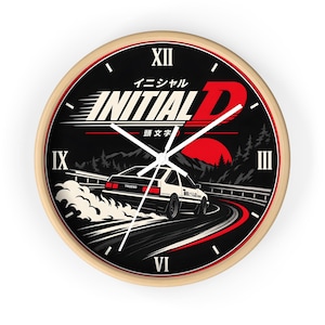 May include: A round wall clock with a light wood frame and a black face featuring the Initial D logo, Japanese text, and a graphic of a white car drifting on a mountain road at night with a large red sun in the background and Roman numerals.