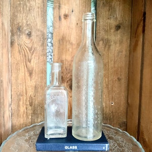 Set of two vintage French glass bottles. One is an antique Gellé Frères perfum bottle, the other a liquid measure. Lovely to display!