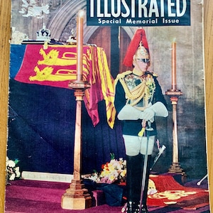 Pode incluir: Uma capa de revista com uma foto em preto e branco de um homem em uniforme militar de pé em frente a um caixão coberto com uma bandeira vermelha e dourada. O título da revista é "Illustrated" e o texto "Special Memorial Issue" está abaixo do título.
