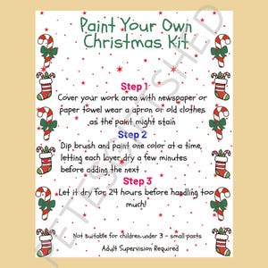 Op de afbeelding: Een wit instructieblad getiteld Paint Your Own Christmas Kit met rode sterren. De rand is versierd met illustraties van zuurstokken en kerstsokken. De tekst bevat drie genummerde stappen voor het schilderen en diverse veiligheidswaarschuwingen.