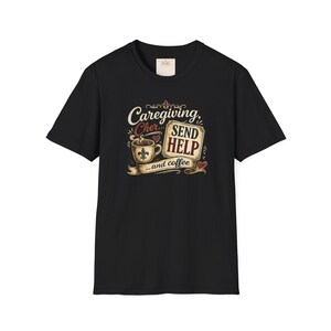 May include: A black short-sleeve t-shirt featuring a graphic print of a steaming coffee cup with a fleur-de-lis symbol, a rectangular sign reading SEND HELP, and the text Caregiving, Cher... and coffee, accented with small red hearts.