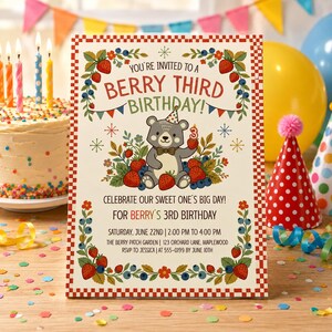 May include: A rectangular birthday invitation card with a red and white checkered border. The text reads: YOU'RE INVITED TO A BERRY THIRD BIRTHDAY. A bear wearing a party hat holds a number three candle, surrounded by strawberries and blueberries.