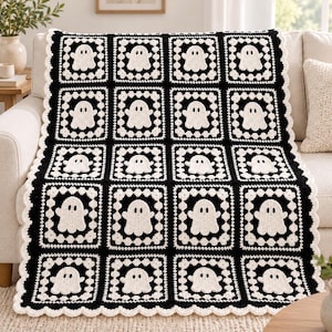 May include: A rectangular crochet blanket featuring a repeating pattern of white ghost motifs centered within individual black square blocks. The blanket is bordered by a scalloped white edge, with each ghost having two black eyes.