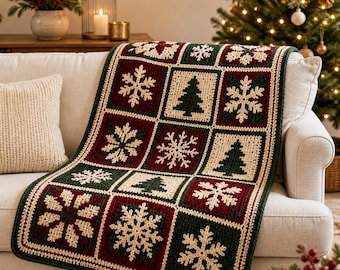 May include: A rectangular crochet blanket featuring a grid of alternating squares in dark green, deep red, and cream. The squares display intricate white snowflake patterns and dark green pine tree motifs, finished with a cream border.