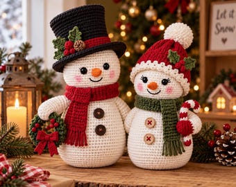 May include: Two crocheted snowmen figures. The left snowman wears a black top hat with holly and a red scarf, holding a small wreath. The right snowman wears a red pom-pom hat with holly and a green scarf, holding a red and white candy cane.