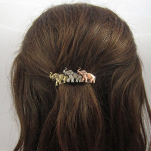 May include: A set of four elephant hair clips in gold, silver, and copper finishes. The elephants are facing the same direction and are arranged in a row.