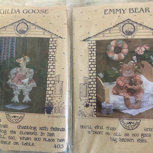 May include: Two vintage craft patterns for making a goose and a bear doll. The patterns feature illustrations of the finished dolls and the text "Gilda Goose" and "Emmy Bear".