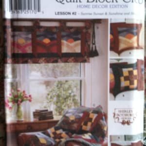 May include: Simplicity Quilt Block Club Home Decor Edition pattern. The cover features a quilt block design with a sunset scene, and a finished quilt and pillow. The pattern includes the text "LESSON #2 - Sunrise Sunset & Sunshine and Sh..."
