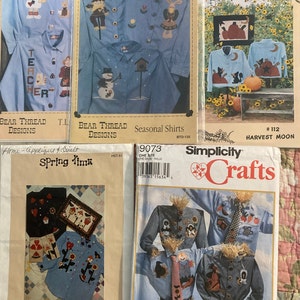 May include: A collection of four sewing patterns for shirts and quilts. The patterns feature a variety of designs, including a scarecrow, a snowman, a teacher, and a harvest moon. The patterns are from Bear Thread Designs and Simplicity Crafts.