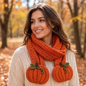 May include: A long, orange, crocheted scarf featuring a textured, open-stitch pattern. The ends of the scarf are finished with two large, three-dimensional, crocheted orange pumpkins, each accented with a small green stem and a curly green vine.