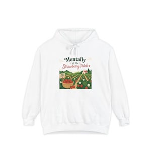 May include: A white hooded sweatshirt featuring a graphic print of a strawberry patch with a basket of strawberries, a small farmhouse, and the text Mentally at the Strawberry Patch with a sign that reads Pick Happy in dark green and red.