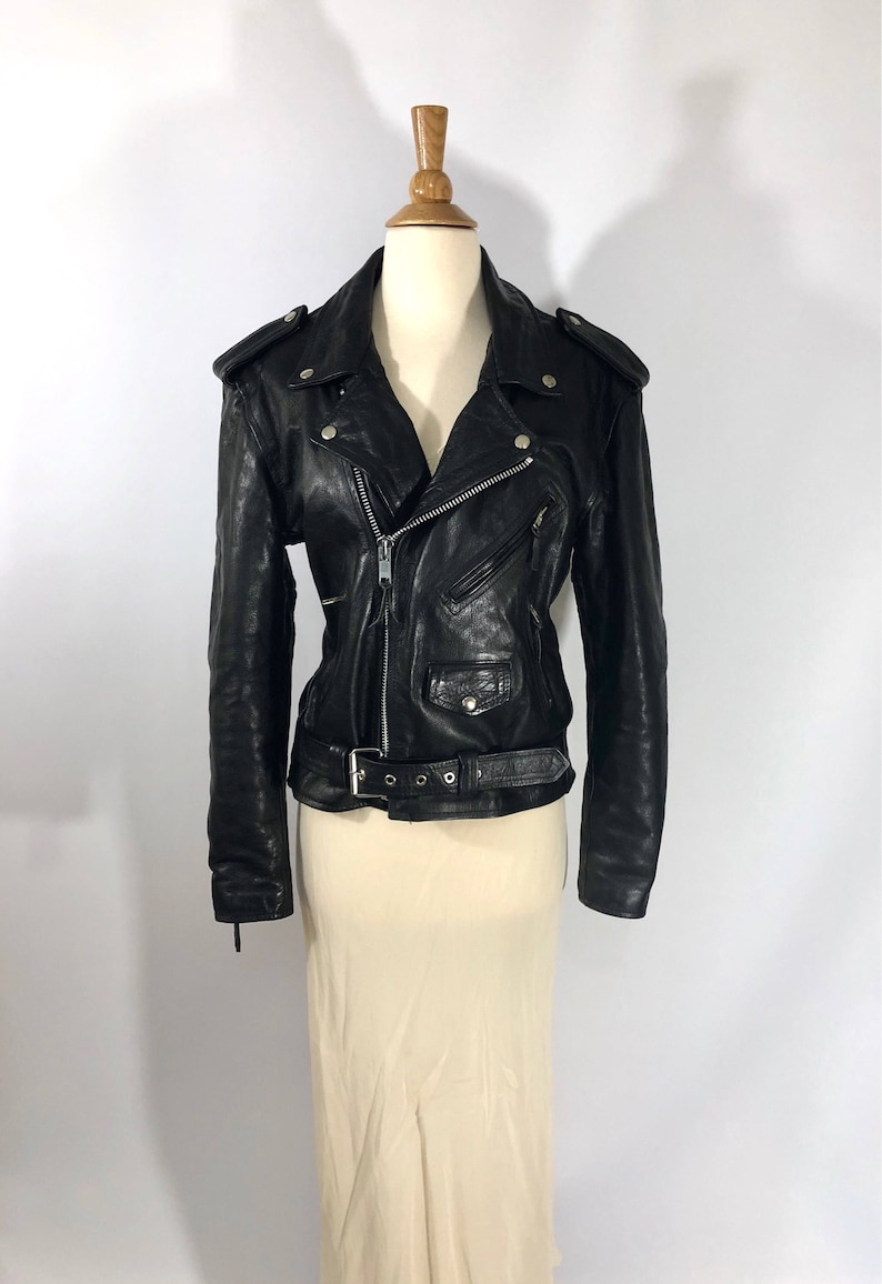 May include: Black leather motorcycle jacket with a zipper closure, a belt, and multiple pockets.