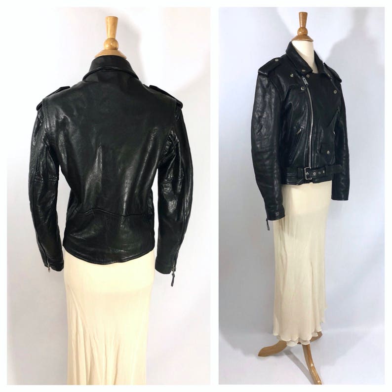 May include: Black leather motorcycle jacket with a zipper closure, multiple pockets, and a belt at the waist.