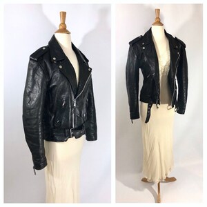 May include: Black leather motorcycle jacket with a zipper closure, a belt, and multiple pockets.