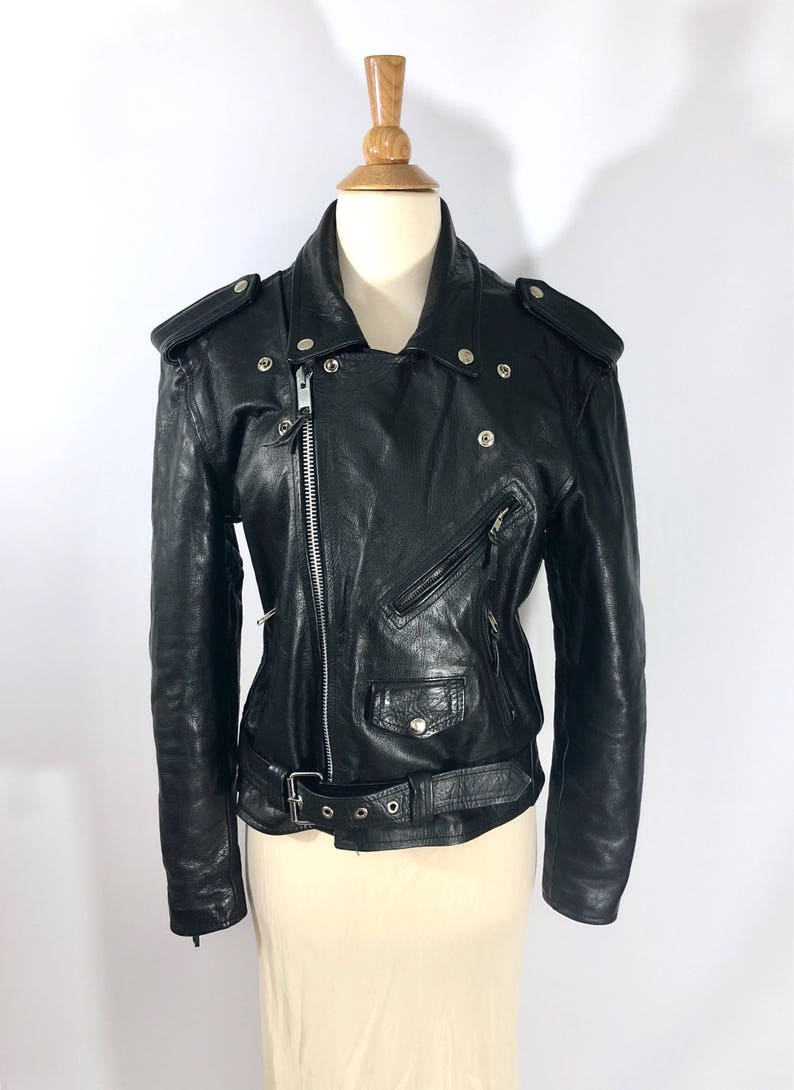 May include: Black leather motorcycle jacket with a zipper closure, a belt at the waist, and multiple pockets.