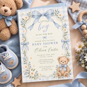 Puede incluir: Una tarjeta de invitación para baby shower con un borde de cuadros azul claro, un lazo azul grande en la parte superior y detalles florales. El texto dice: A little boy is on the way, please join us for a baby shower for Olivia Carter.