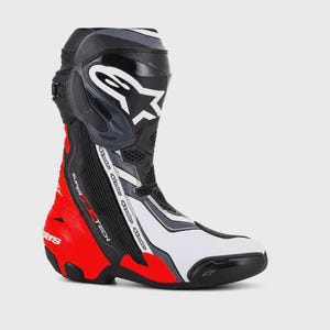 以下が含まれることがあります： 上部のすね部分にAlpinestarsのロゴが入った、黒、白、赤のオートバイ用ブーツ。サイドジッパー、テクスチャ加工されたパネル、足首の側面に垂直にプリントされたSupertechの文字が特徴です。